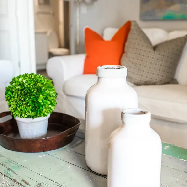three white vases are on a table in a living room