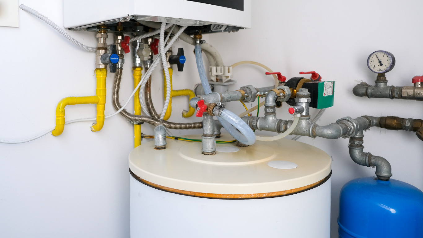 Water heater and plumbing with valves, gauges, and blue tank in a utility room