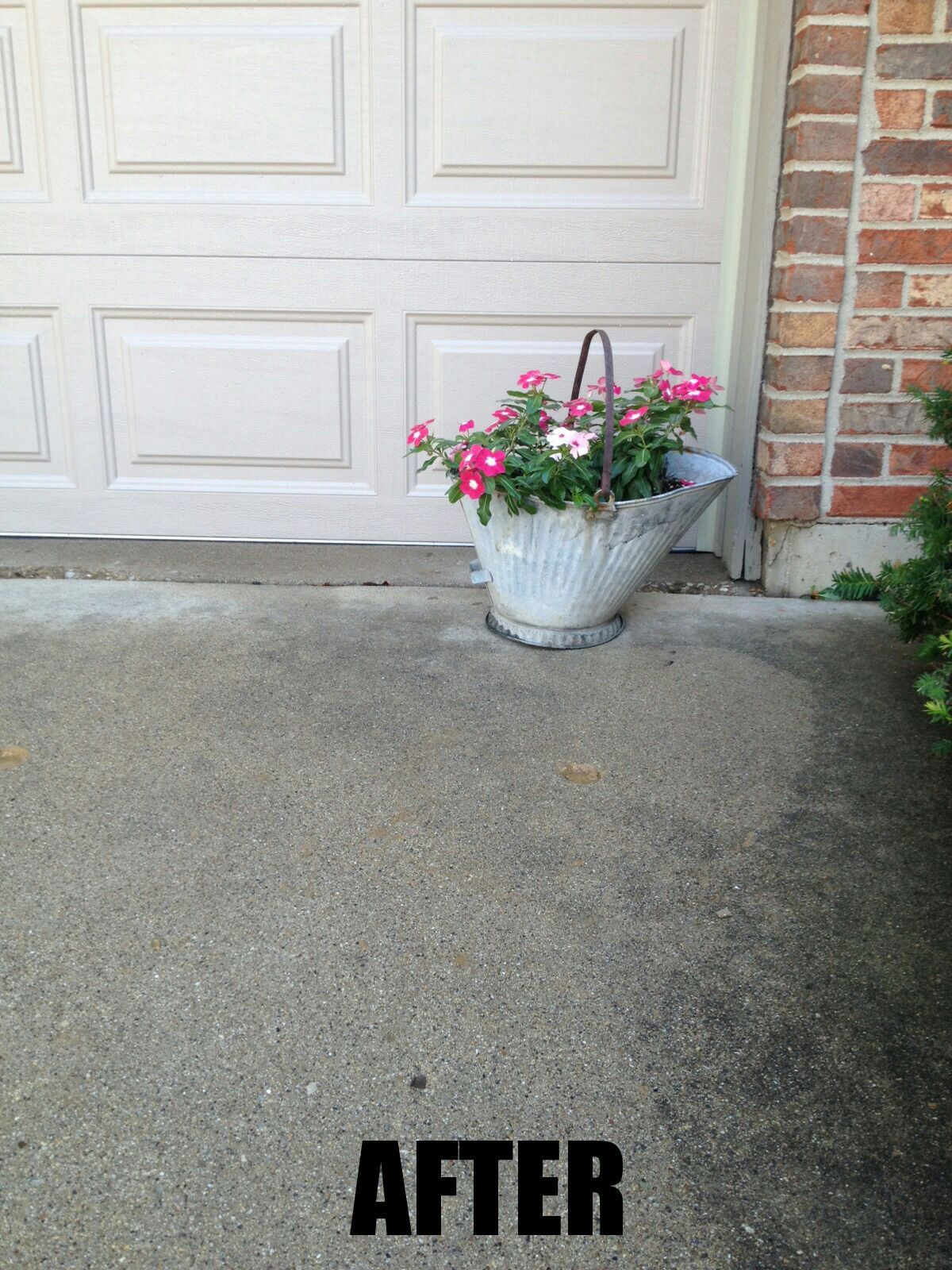 A basket of flowers sits in front of a garage door
