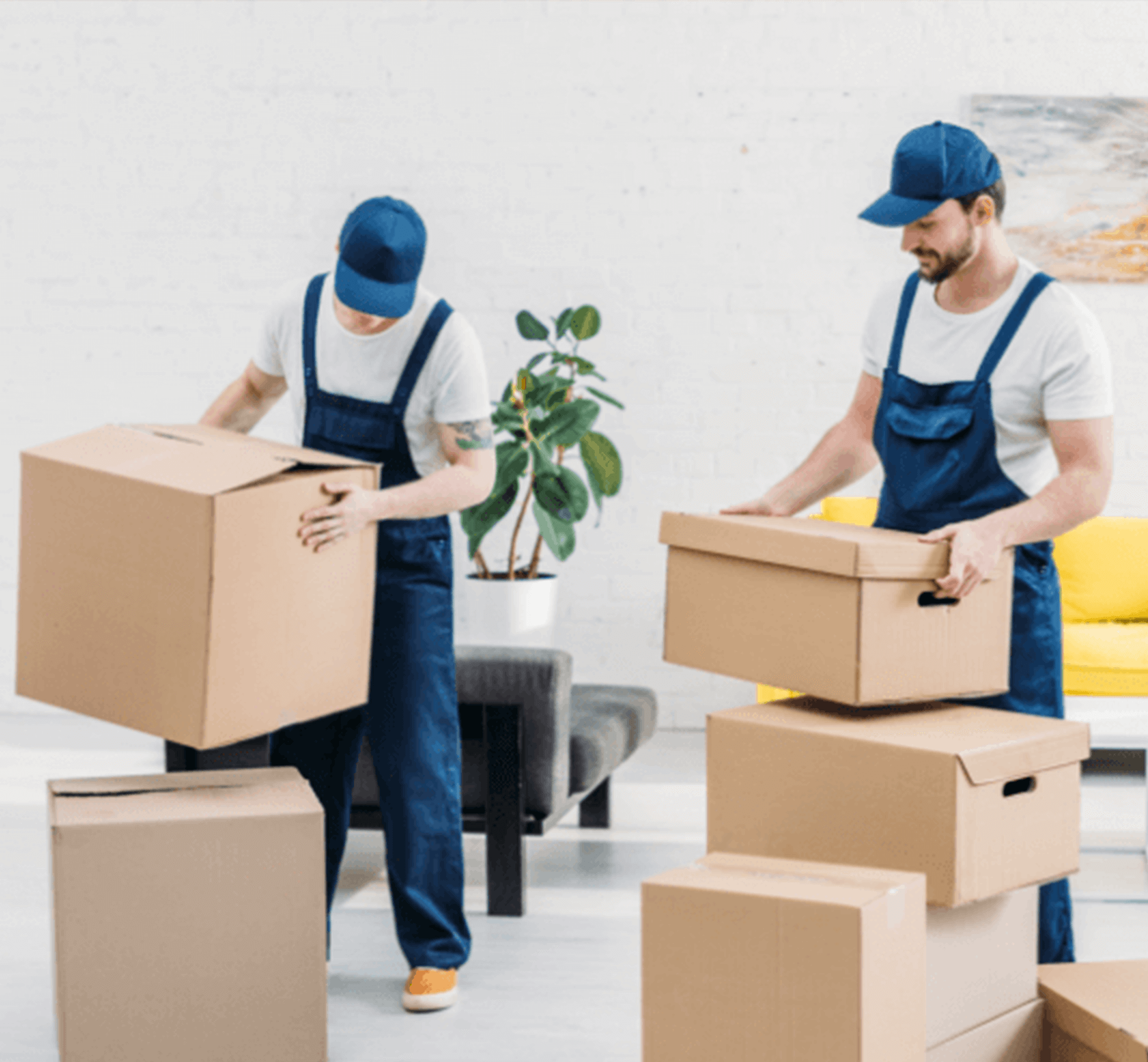 Two professional movers in matching uniforms carefully transport cardboard boxes through a modern and stylish apartment.