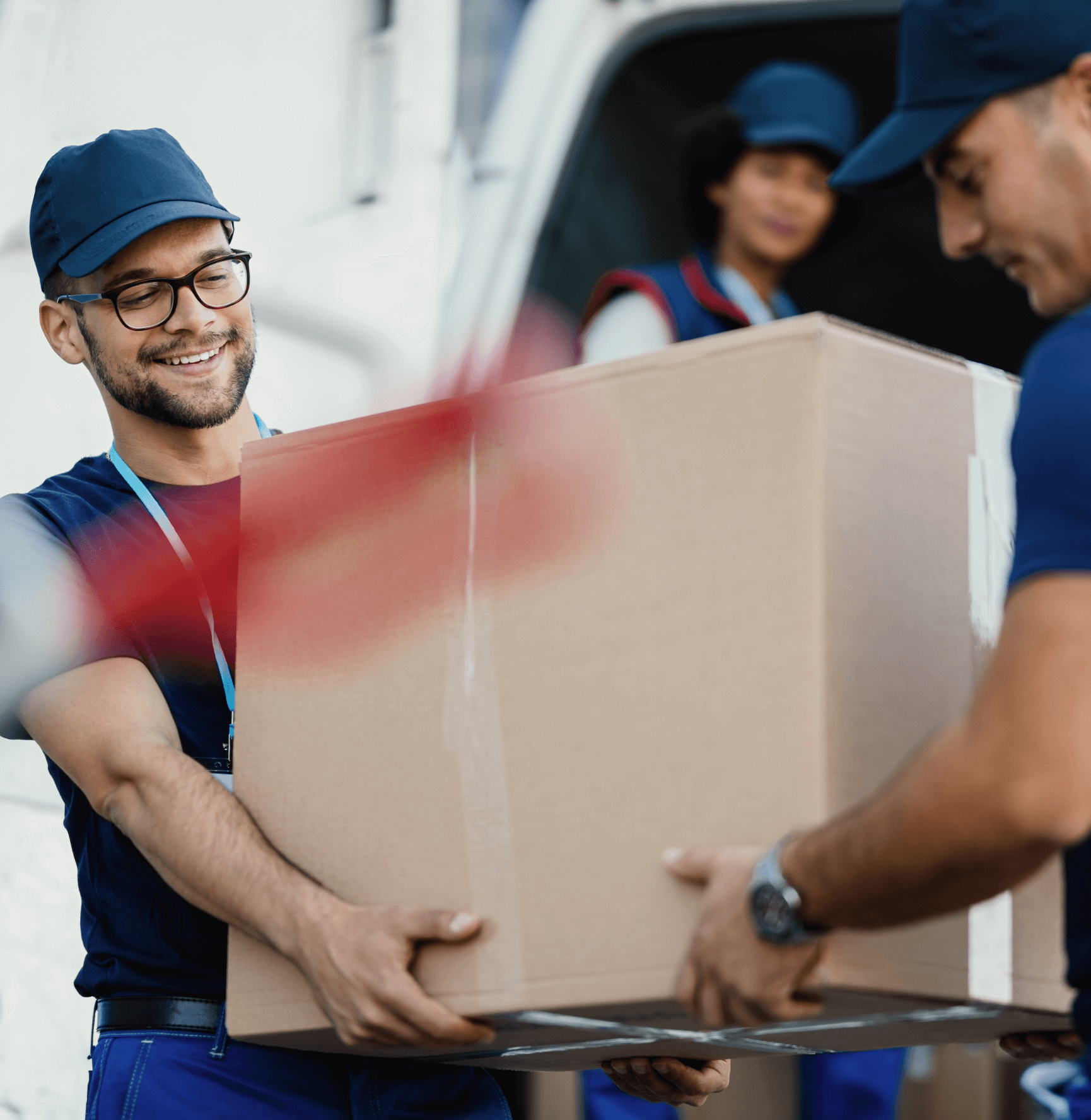 Two cheerful delivery professionals collaborating to load a cardboard box into a delivery van, ensuring a smooth and efficient process.