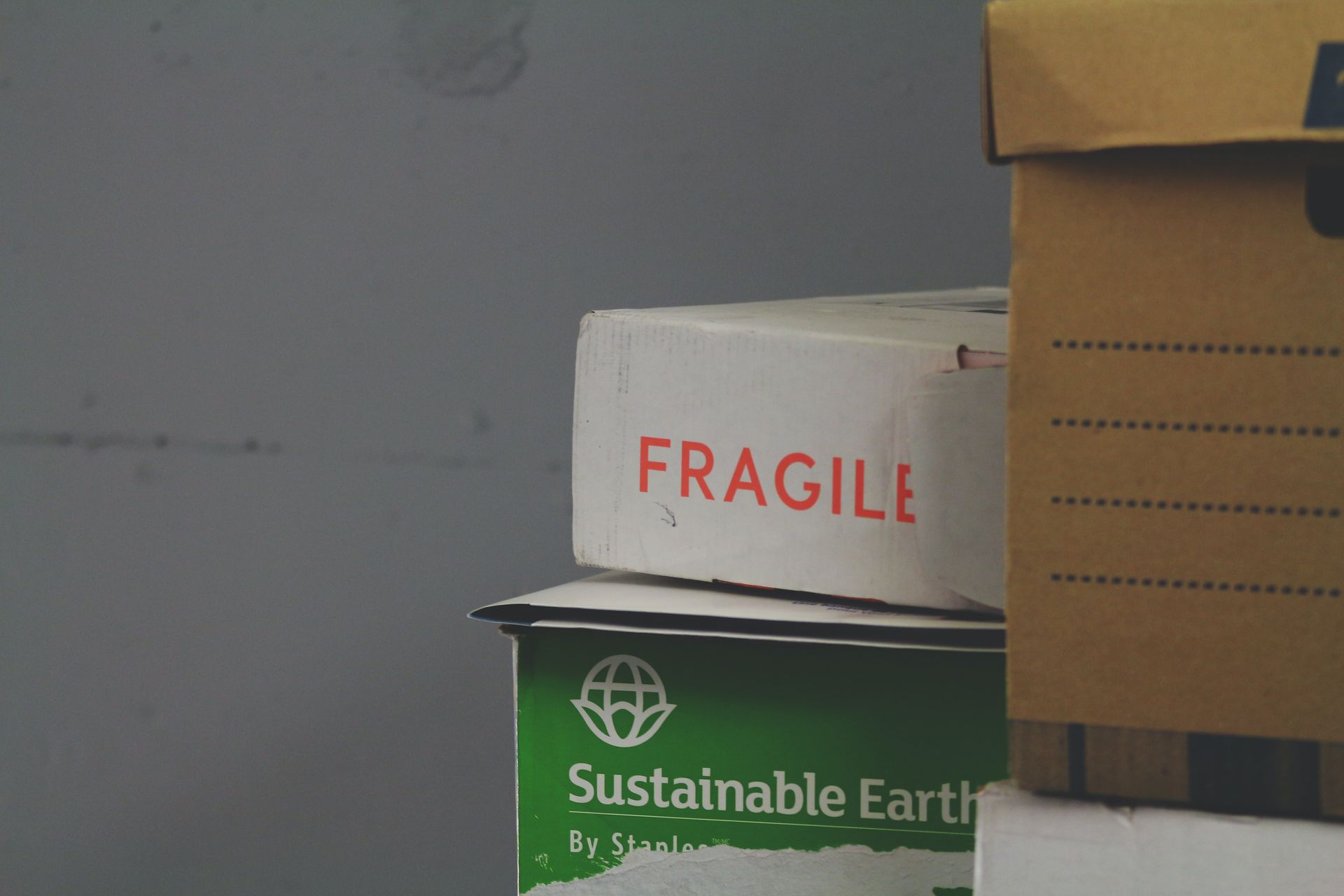 Stack of cardboard boxes for moving, one box prominently labeled as fragile.
