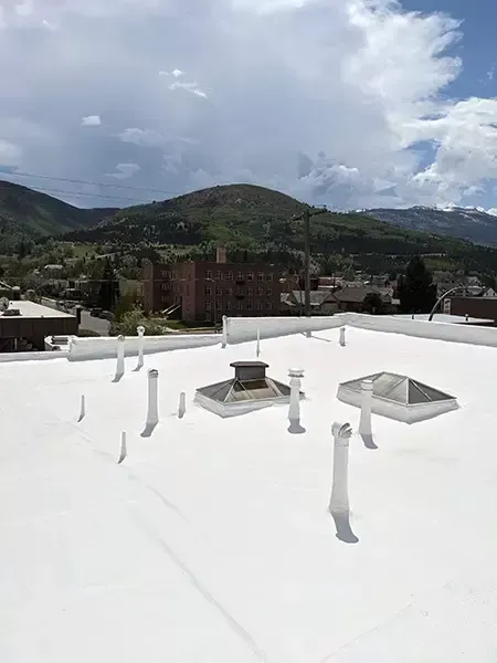 A man is working on a white roof.