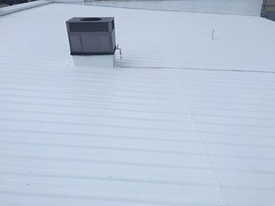 A white roof with a chimney on top of it.