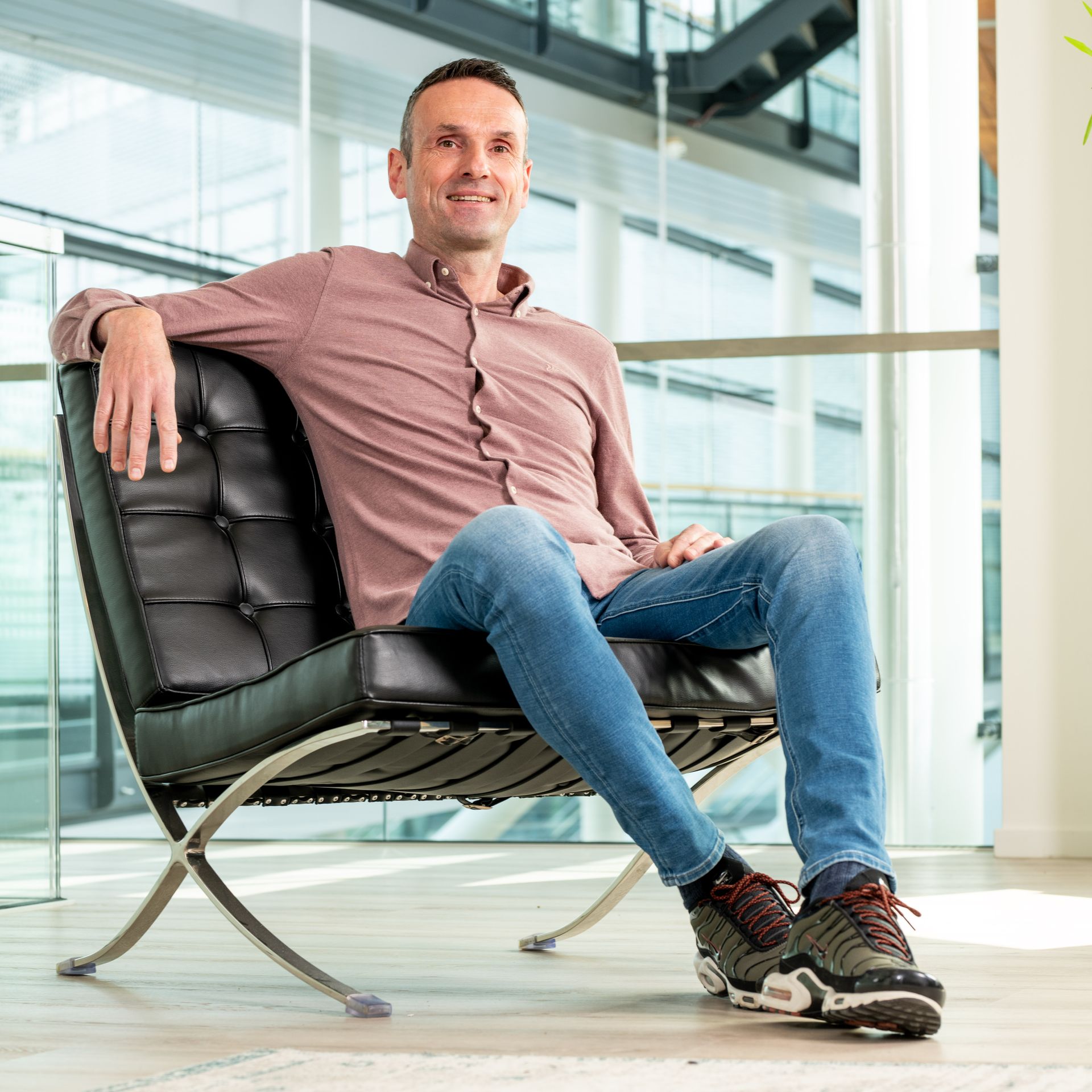 A man is sitting in a chair in front of a window.