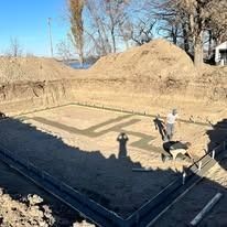 A man is standing in the middle of a dirt field.