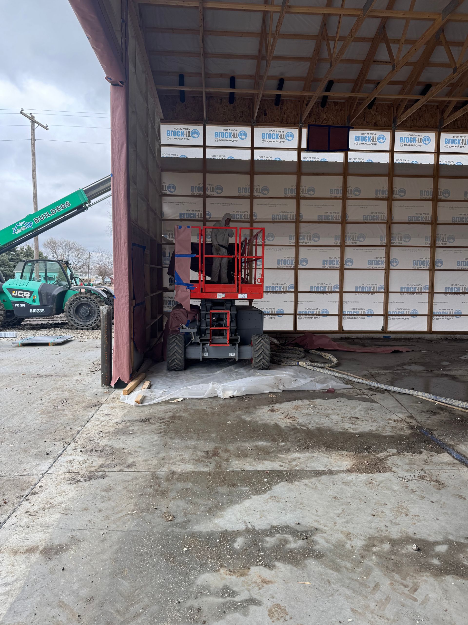 A construction vehicle is parked in front of a building under construction.