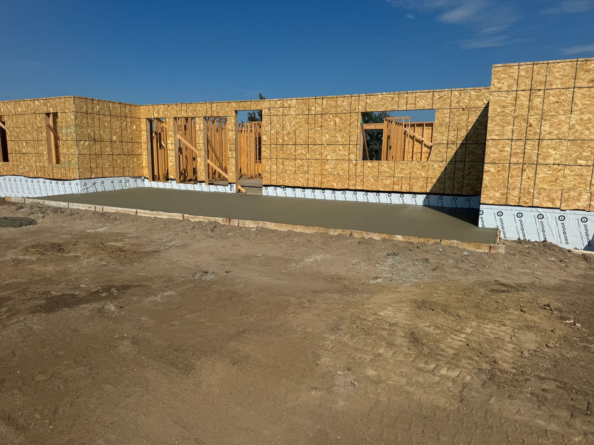 A house is being built in the middle of a dirt field