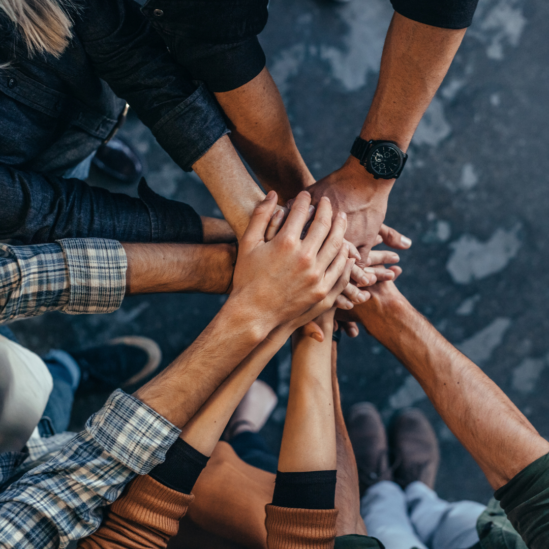 team coming together hands in the middle