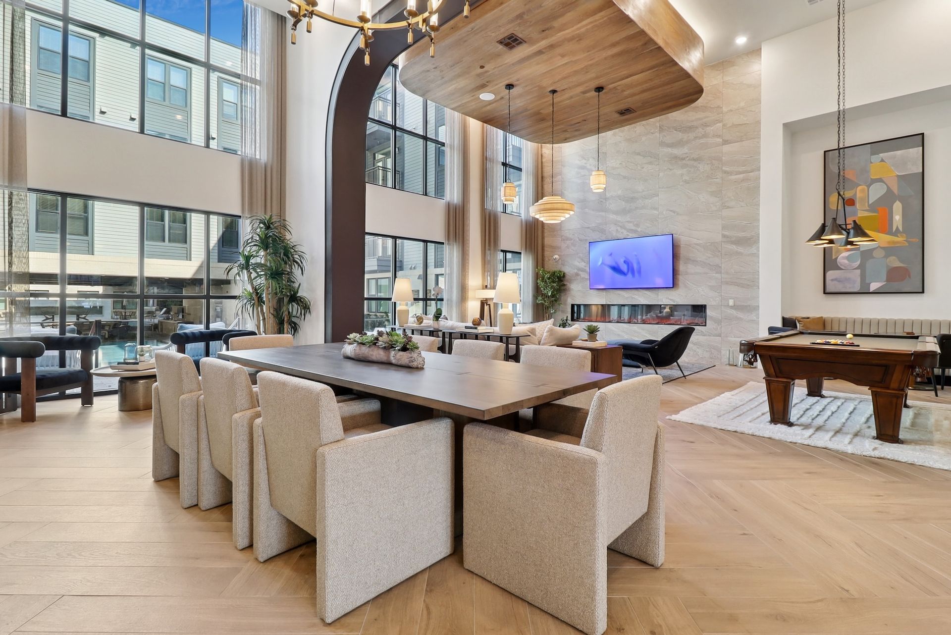 A large room with a table and chairs and a pool table.