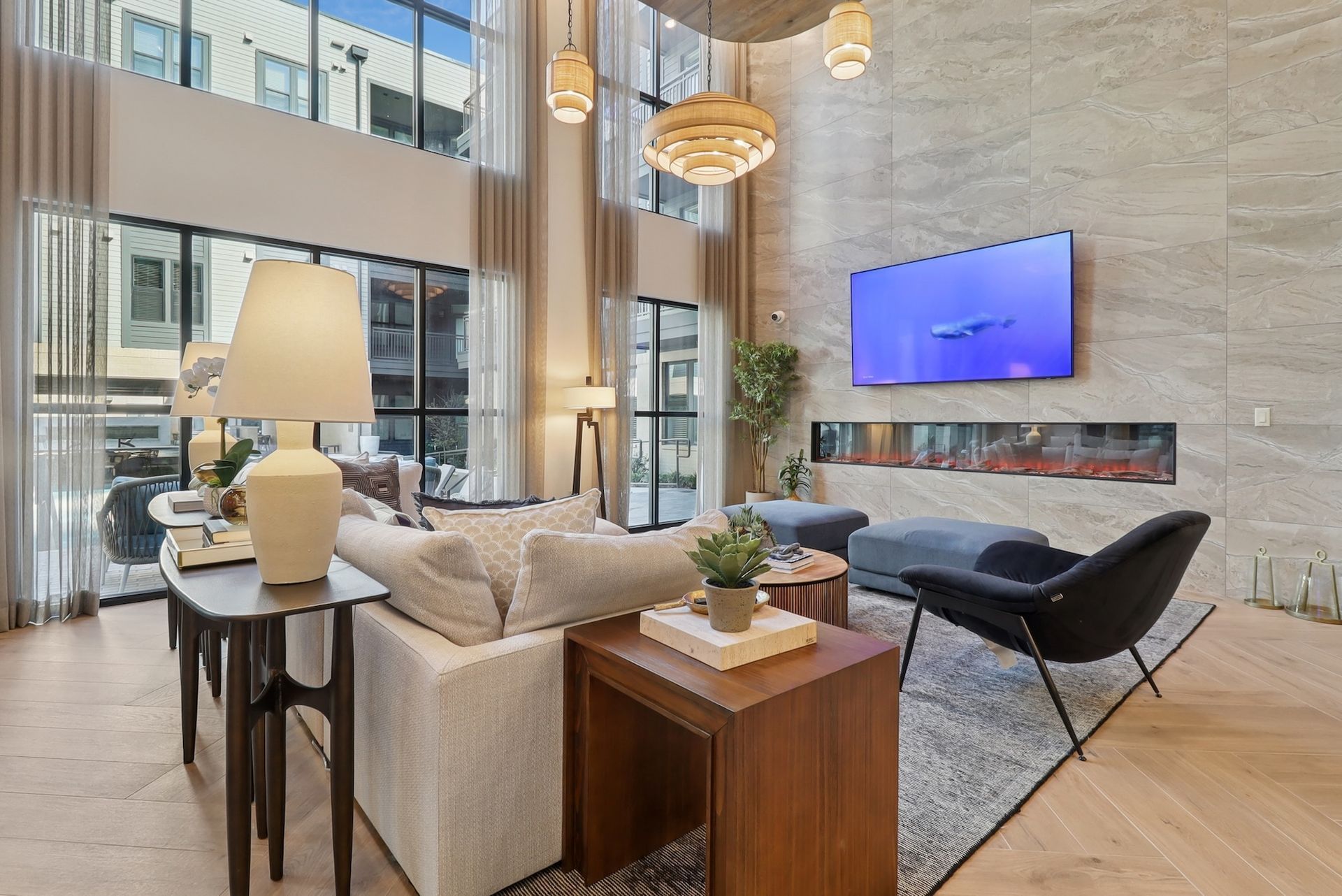 A living room with a couch , chairs , tables and a television.