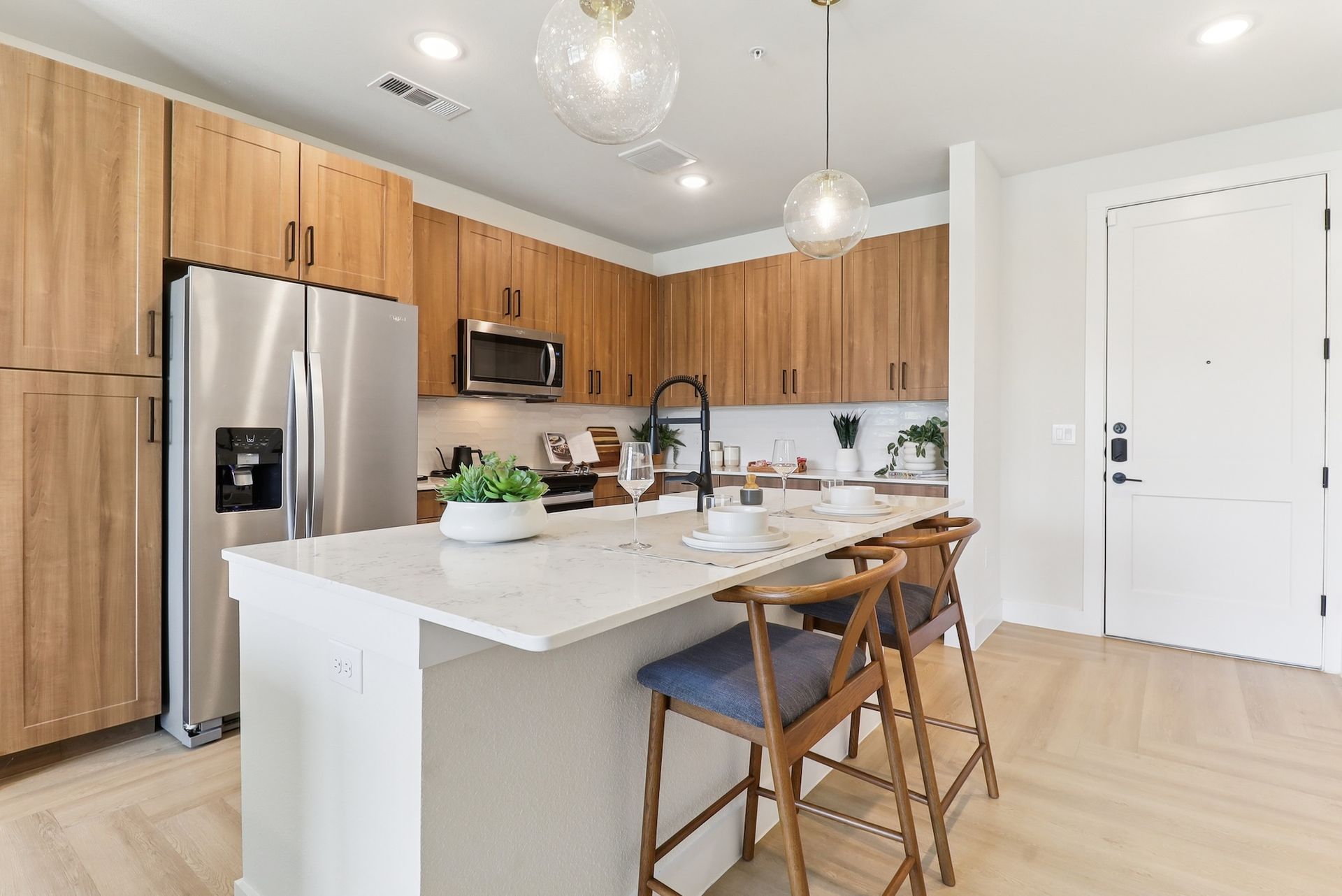 A kitchen with stainless steel appliances , wooden cabinets , and a large island.