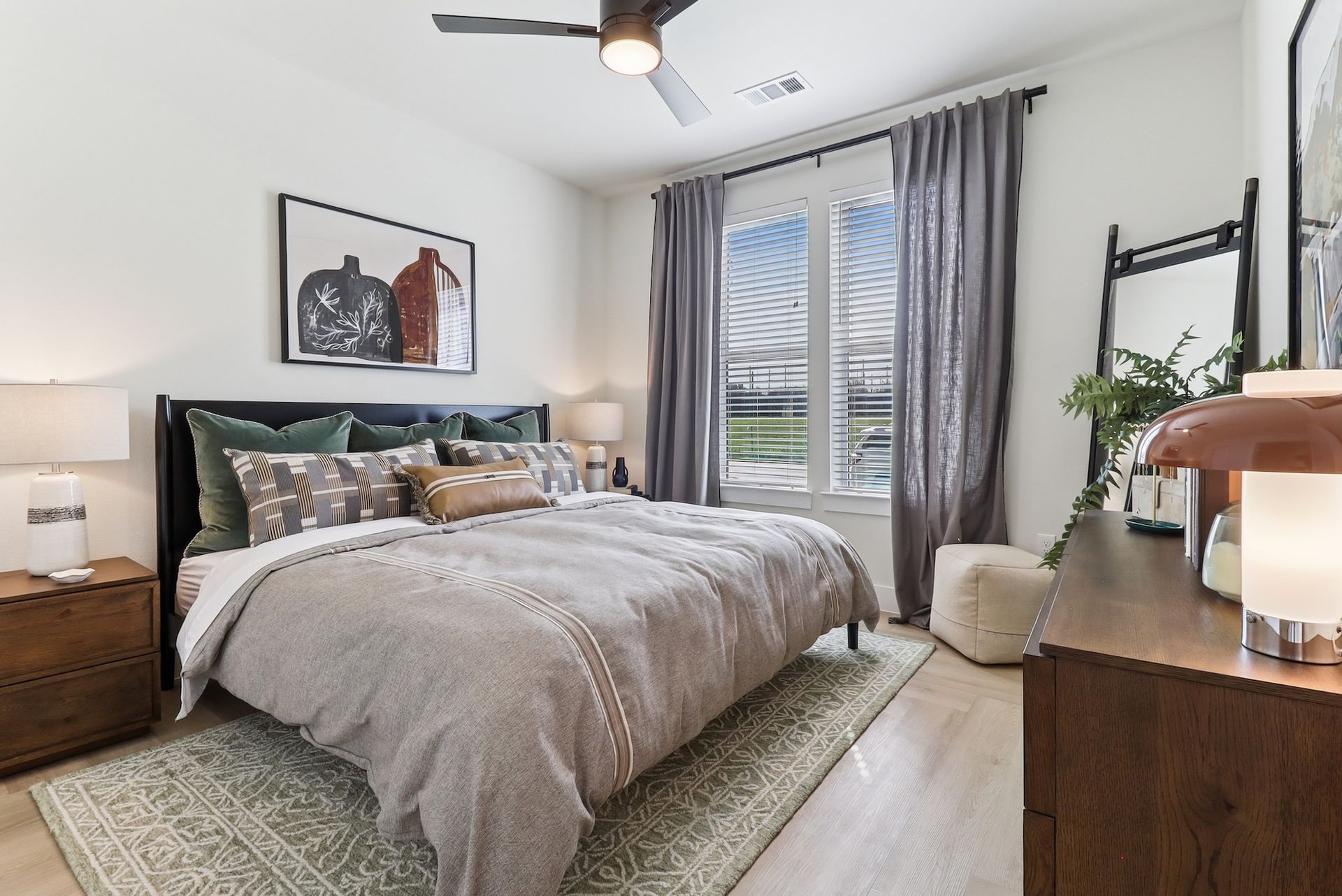 A bedroom with a large bed and a ceiling fan.