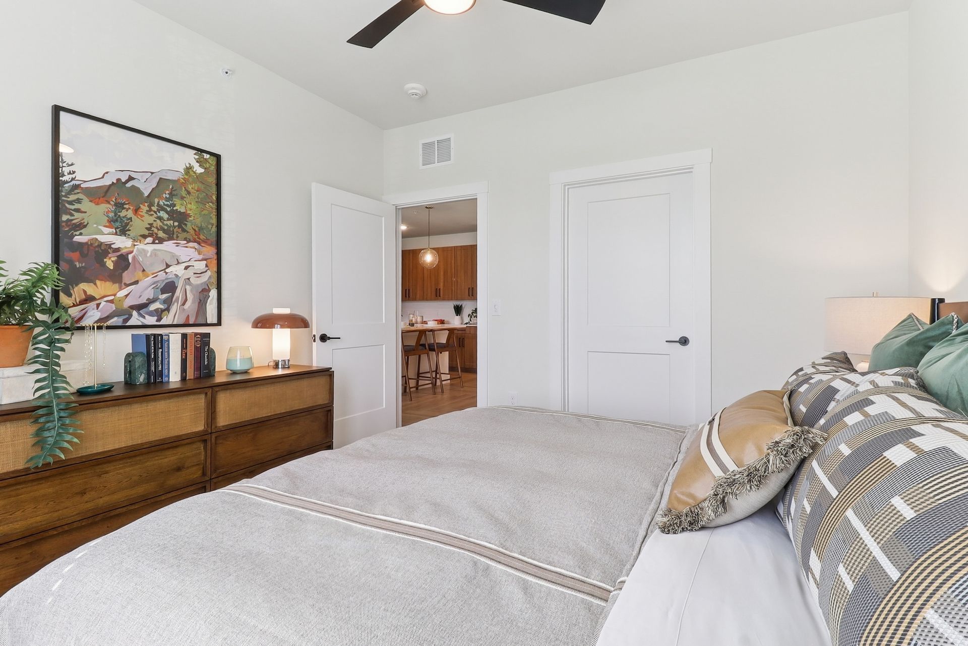 A bedroom with a large bed and a ceiling fan.