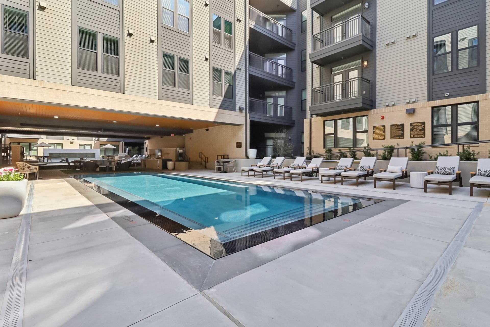 There is a large swimming pool in the middle of a building.