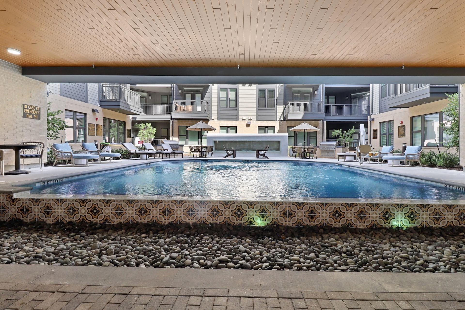 A large swimming pool surrounded by chairs and umbrellas