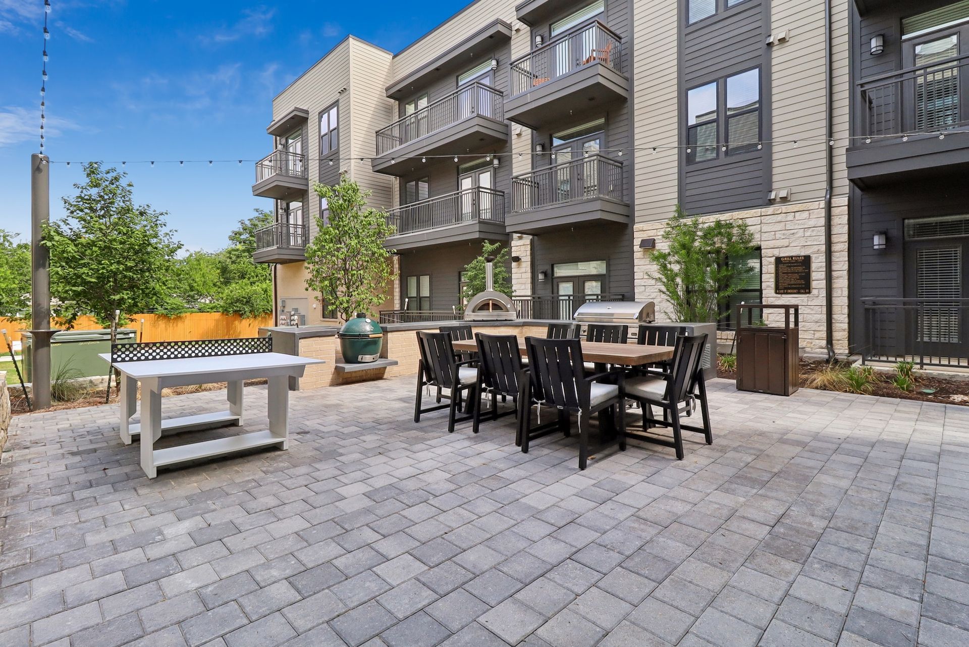 A patio with a table and chairs in front of a building.