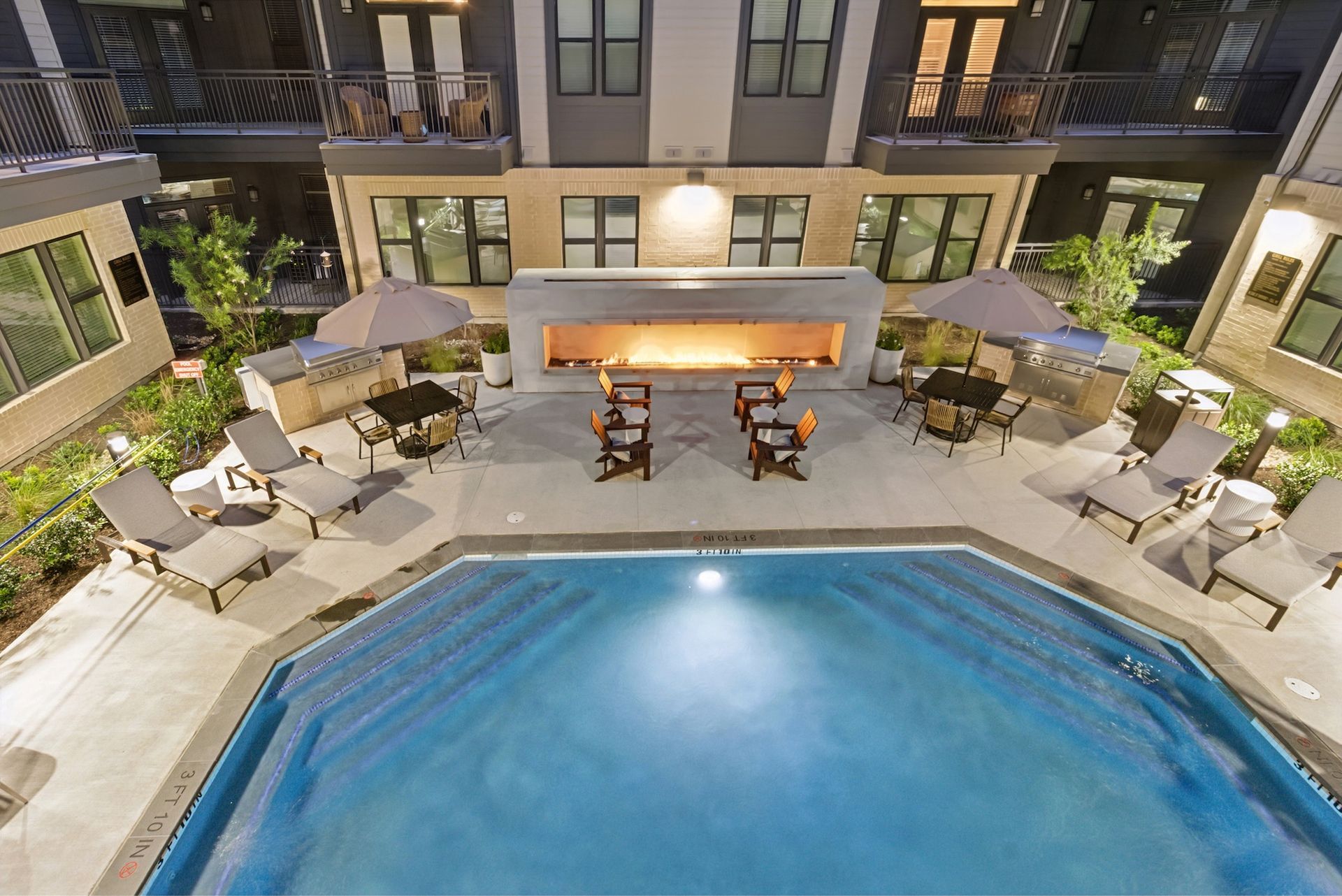 An aerial view of a swimming pool in front of a building