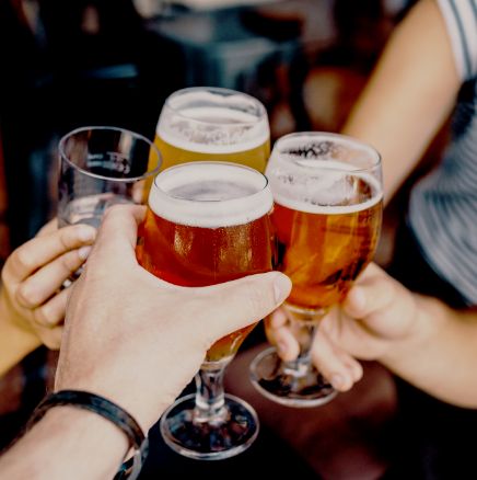 A group of people are toasting with glasses of beer.