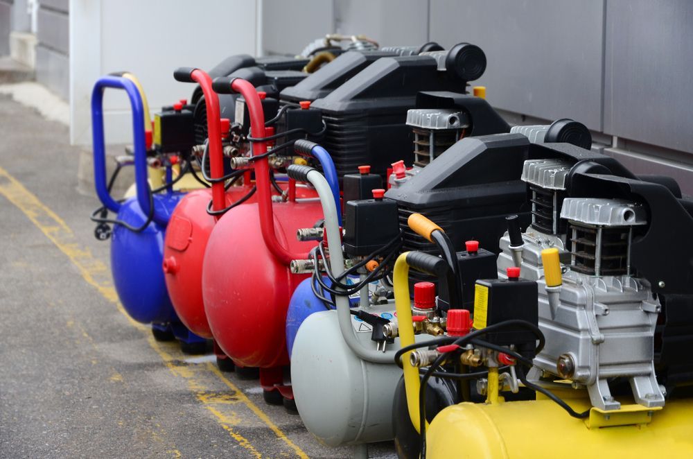 Row Of Colorful Air Compressors Lined Up Outdoors, Ready For Use — Whitsunday Mowers In Airlie Beach, QLD