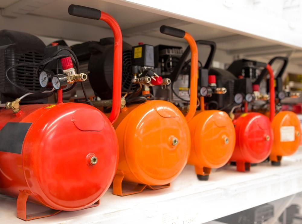 A Row Of Air Compressors Are Lined Up On A Shelf In A Store — Whitsunday Mowers In Airlie Beach, QLD