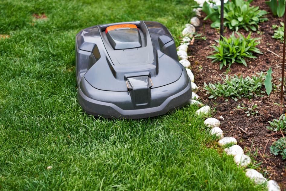 A Robotic Lawn Mower Is Sitting On Top Of A Lush Green Lawn — Whitsunday Mowers In Airlie Beach, QLD