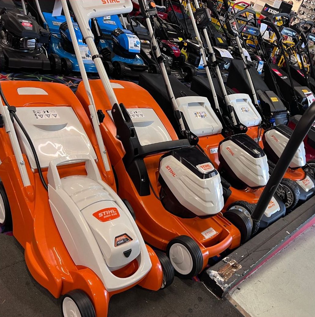 Row Of Orange And White Lawnmowers With Black Accents On Display In A Store — Whitsunday Mowers In Airlie Beach, QLD