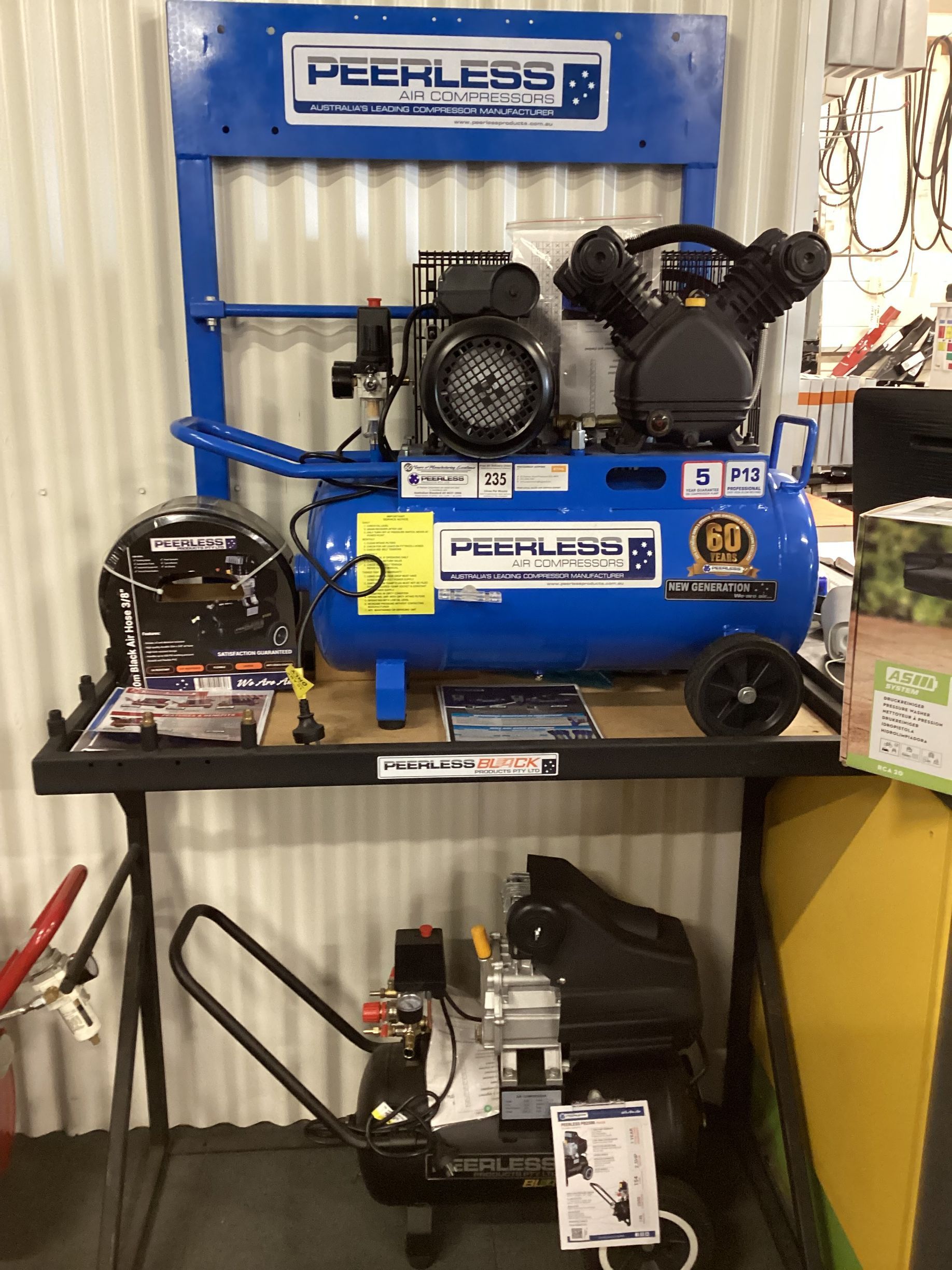 A Row Of Air Compressors Are Lined Up On A Shelf In A Store — Whitsunday Mowers In Cannonvale, QLD