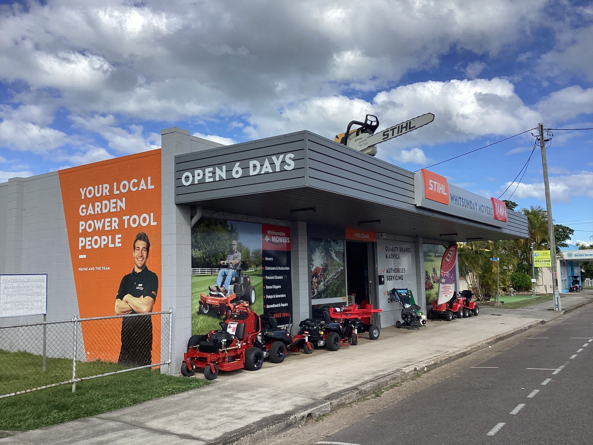 A Man Is Working On A Lawn Mower In A Garage — Whitsunday Mowers In Airlie Beach, QLD