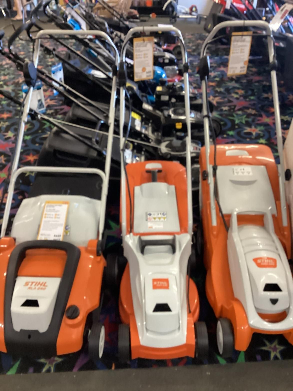 A Row Of Orange And White Stihl Lawn Mowers — Whitsunday Mowers In Cannonvale, QLD