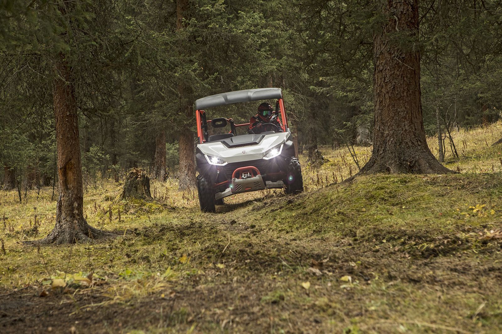 Green Utv Driving on Dirt Path Near a Rocky River, Two People Inside — Whitsunday Mowers In Airlie Beach, QLD