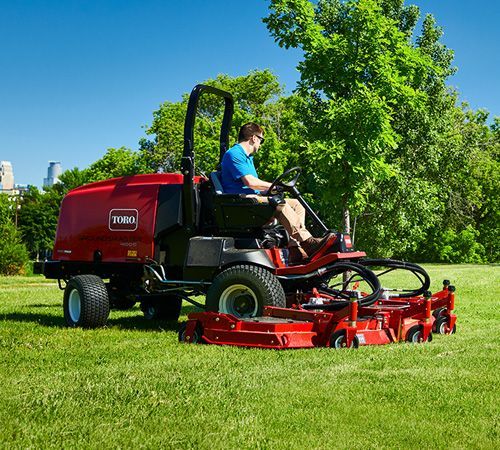A Green Lawn Mower Is Sitting On Top Of A Lush Green Lawn — Whitsunday Mowers In Airlie Beach, QLD