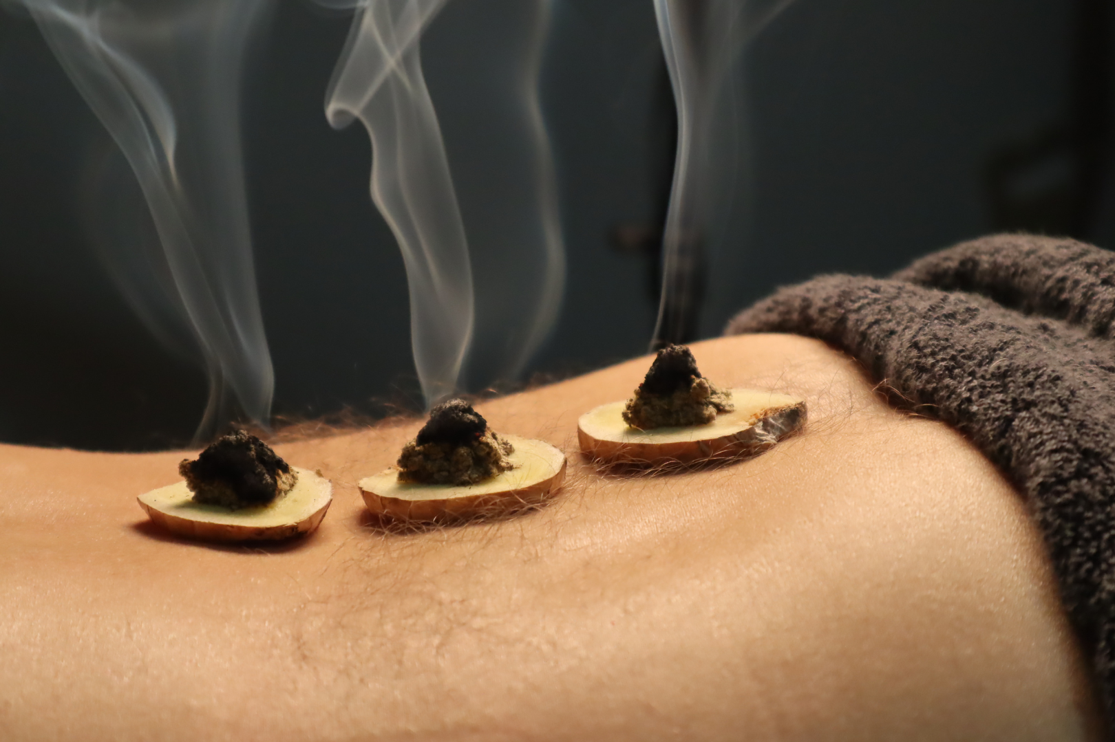 A person is getting a massage with smoke coming out of their back.