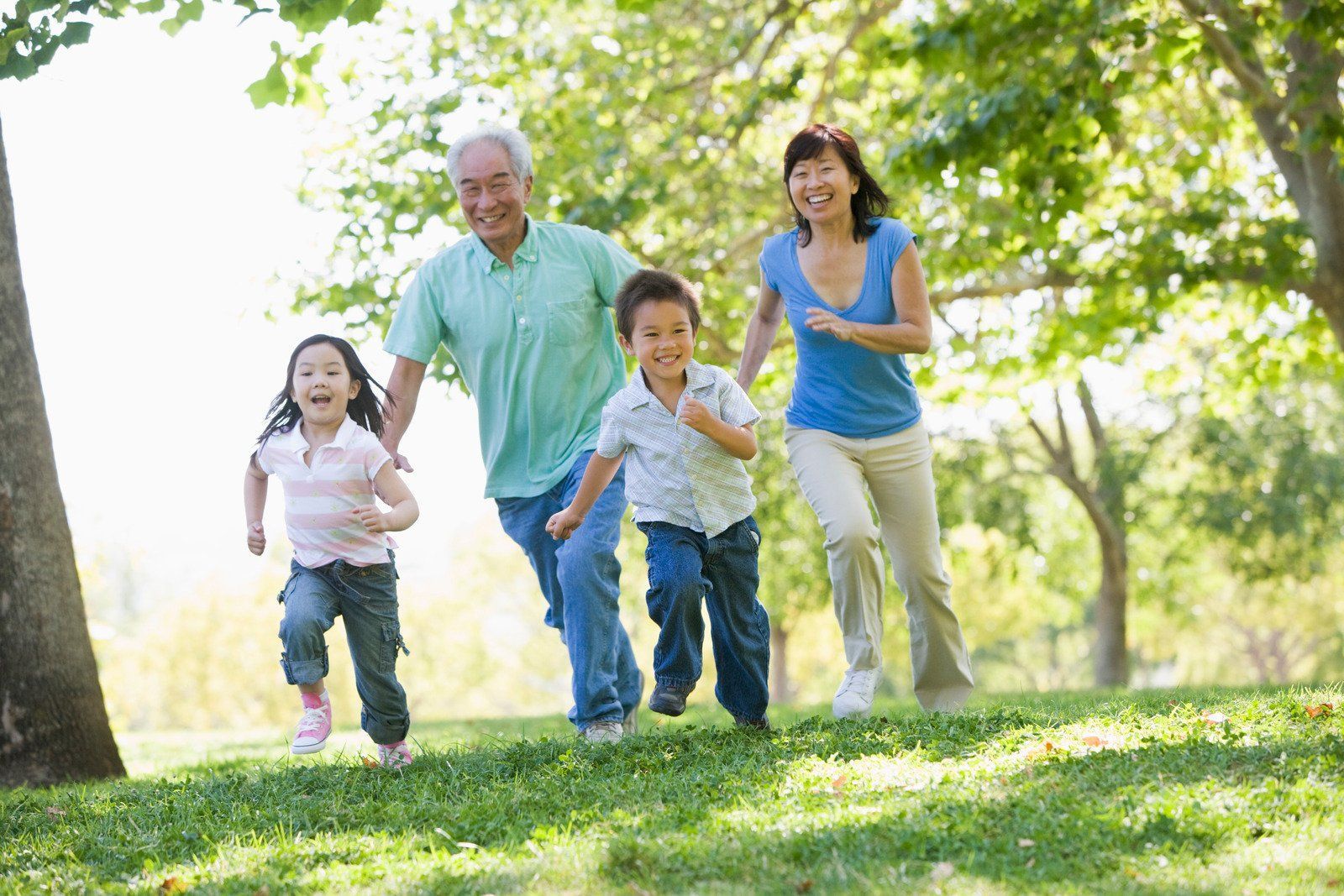A family is running in a park on a sunny day.