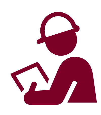 A man wearing a hard hat is reading a book.
