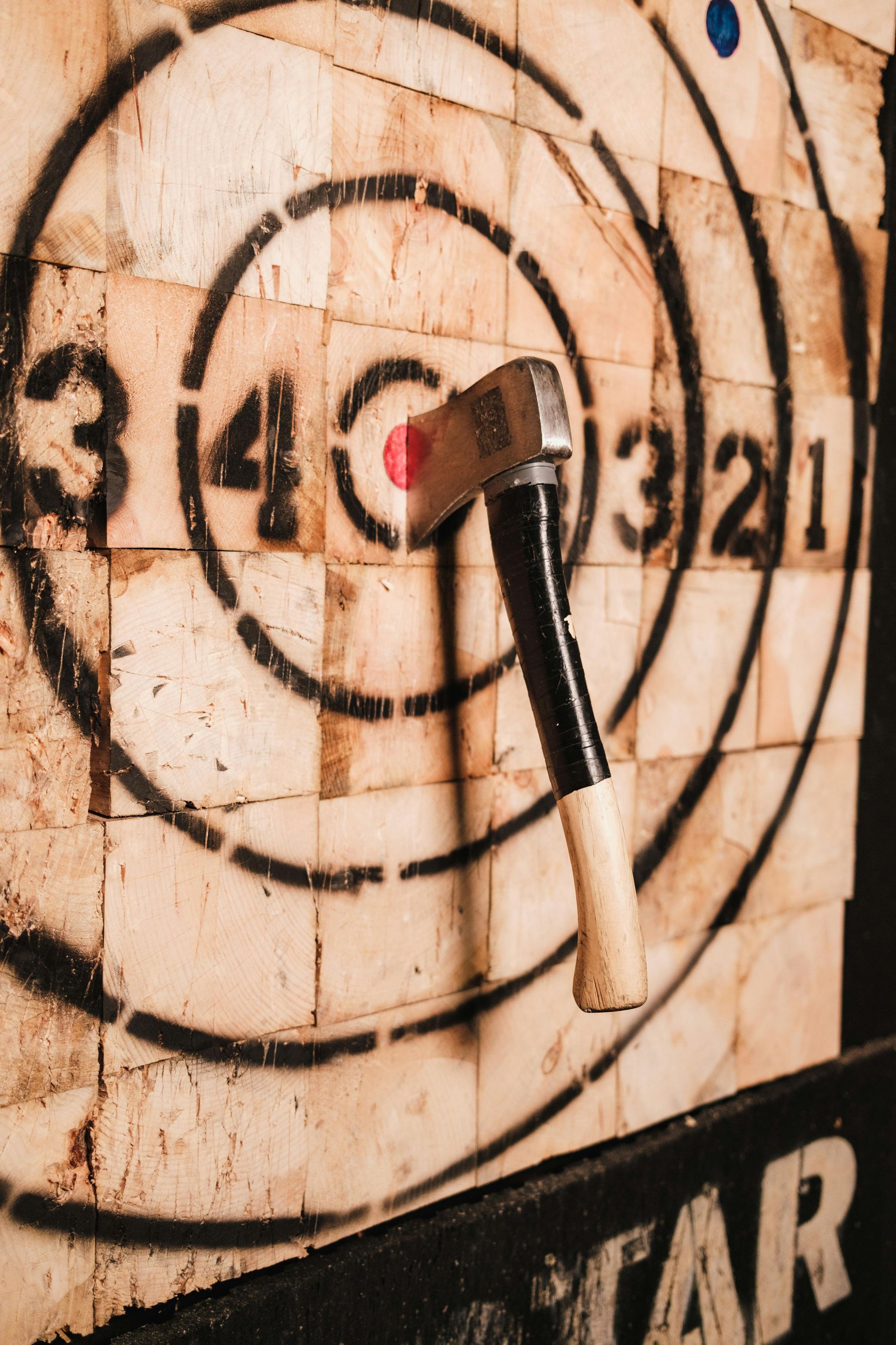 Axe embedded in the bullseye of a wooden target.