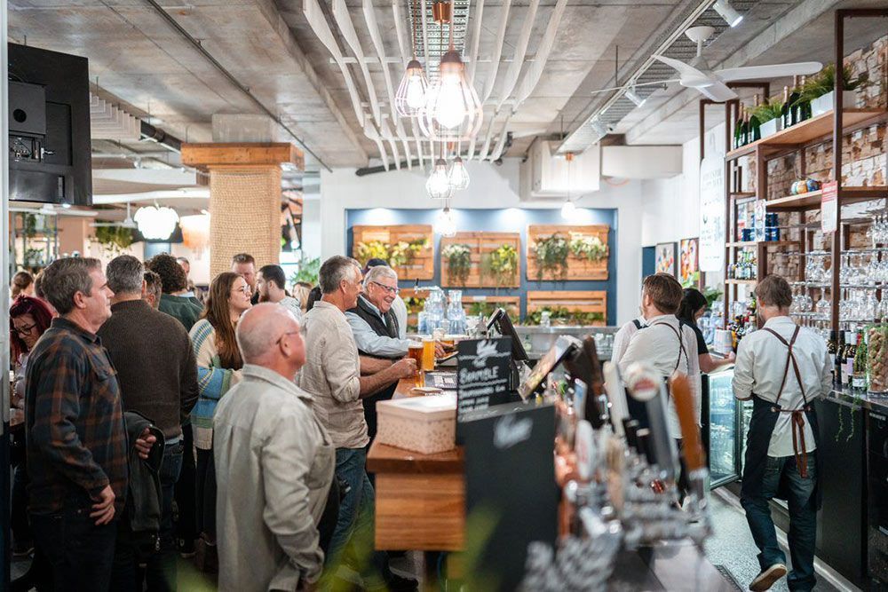A Group of People Are Standing Around a Bar in a Restaurant — Chop ‘n Chill Raby Bay in Cleveland, QLD