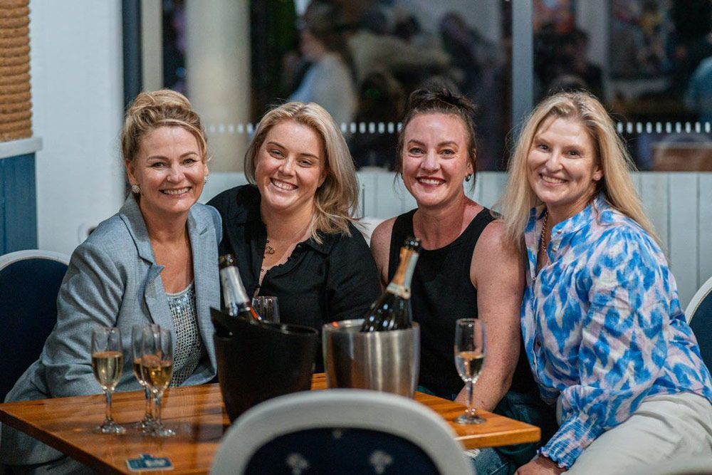 Group of Women Are Sitting at a Table With Wine Glasses and Bottles of Champagne — Chop ‘n Chill Raby Bay in Cleveland, QLD