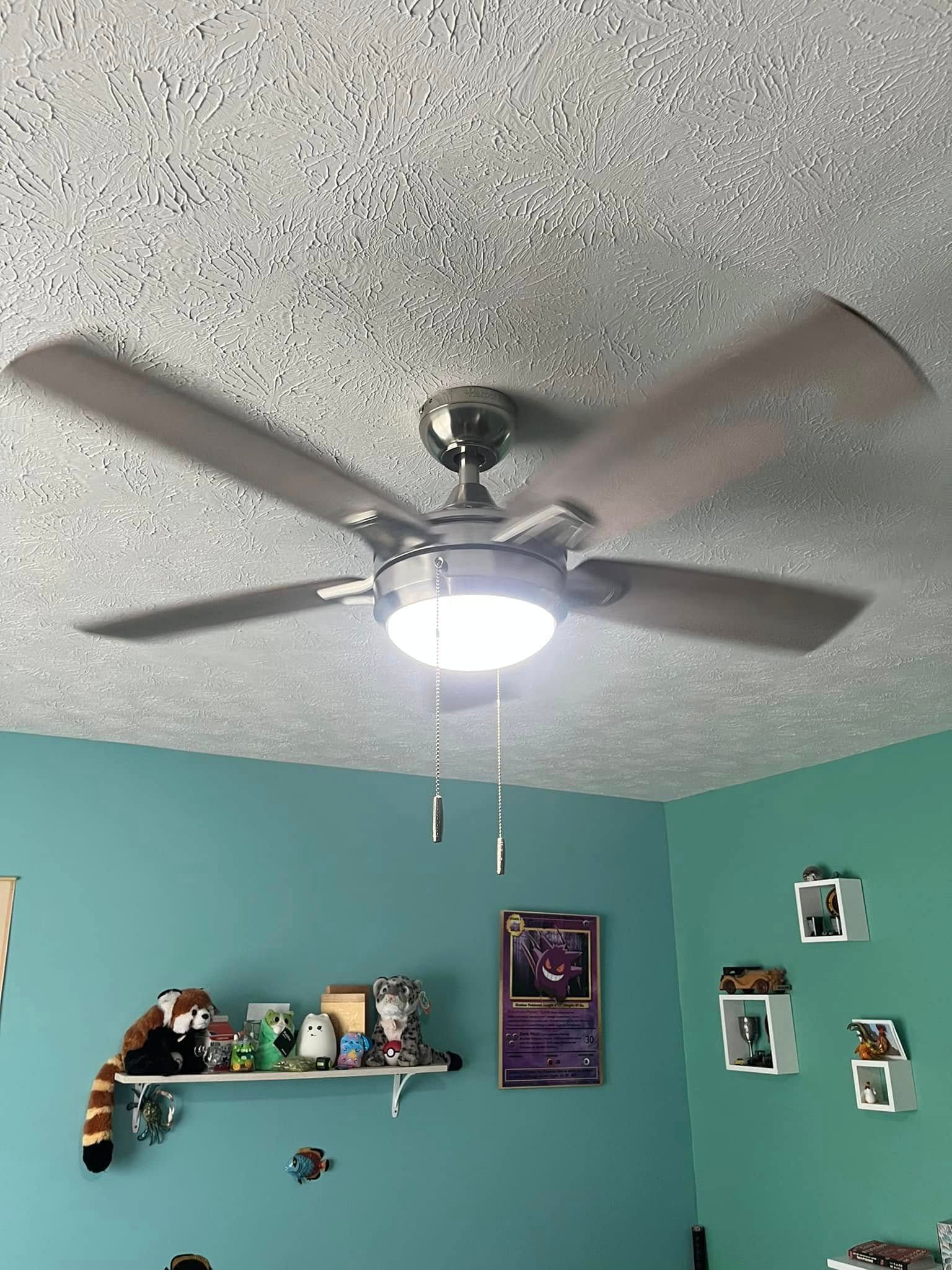 A ceiling fan is hanging from the ceiling in a bedroom.