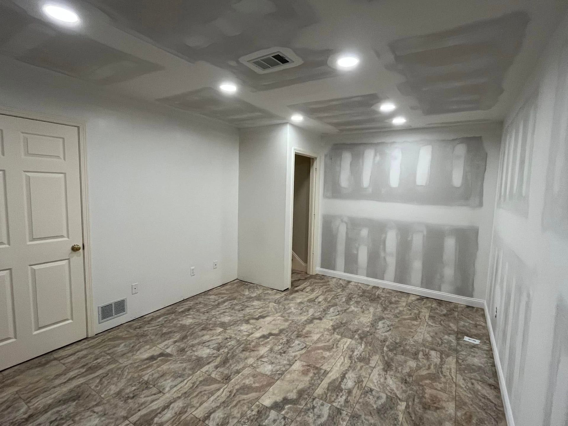 An empty room with drywall on the walls and a door.