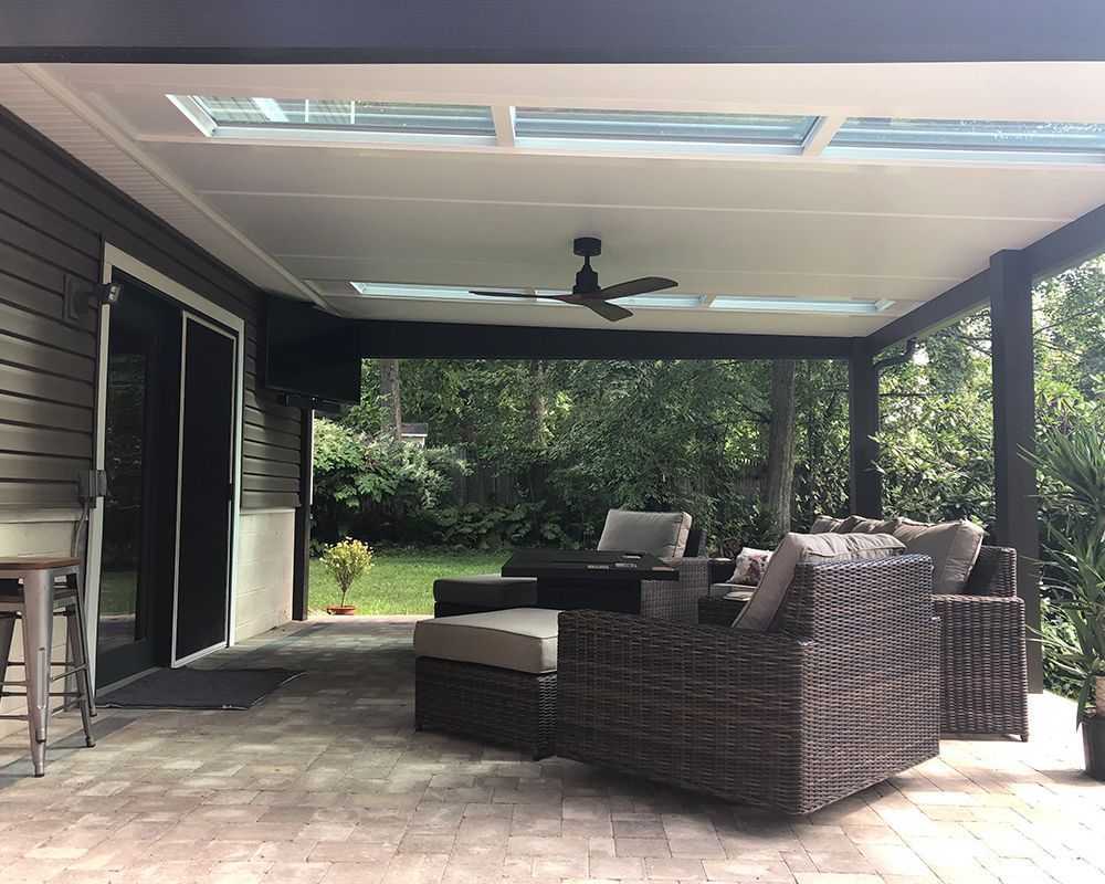 A patio with a table , chairs , and a ceiling fan.