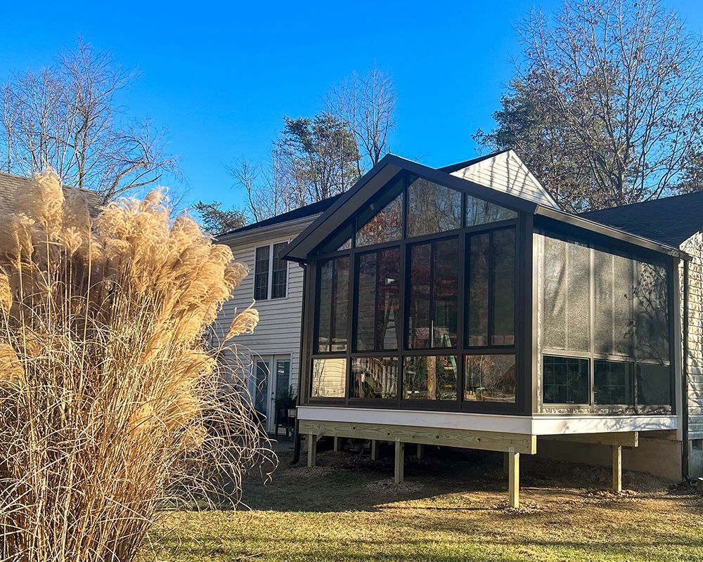 A house with a screened in porch on the side of it.