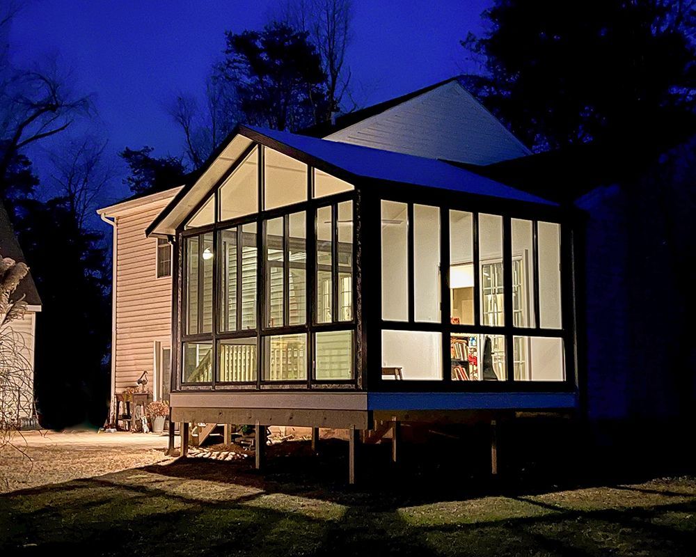 A house with a screened in porch at night