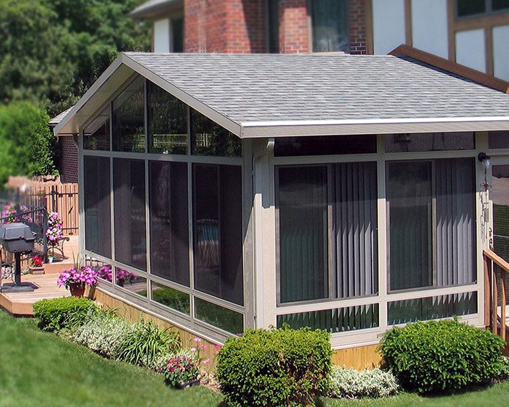 A screened in porch in the backyard of a house