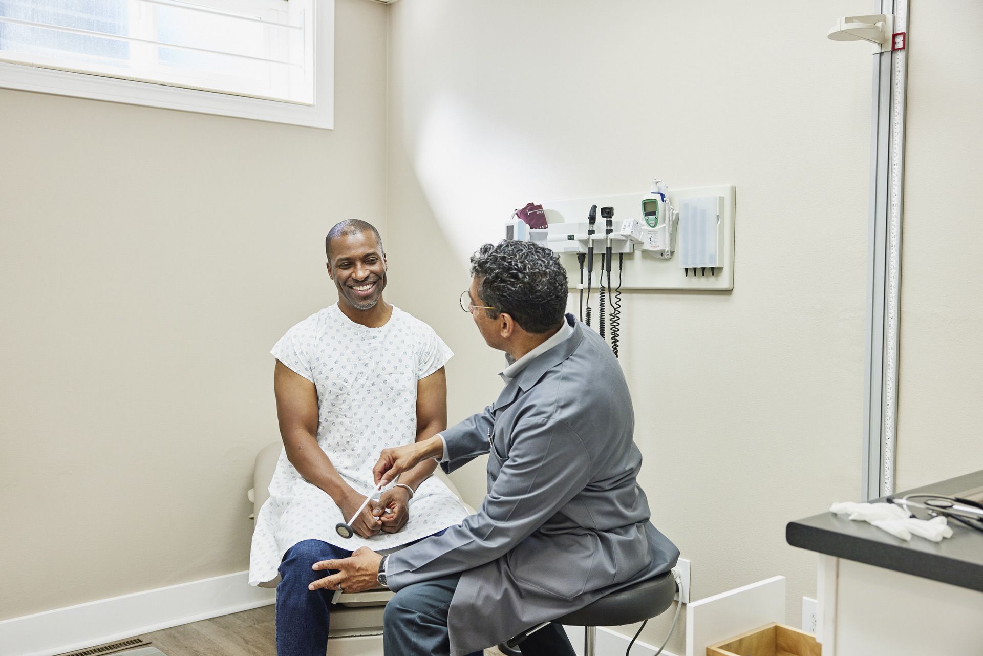 A doctor is talking to a patient in a hospital room