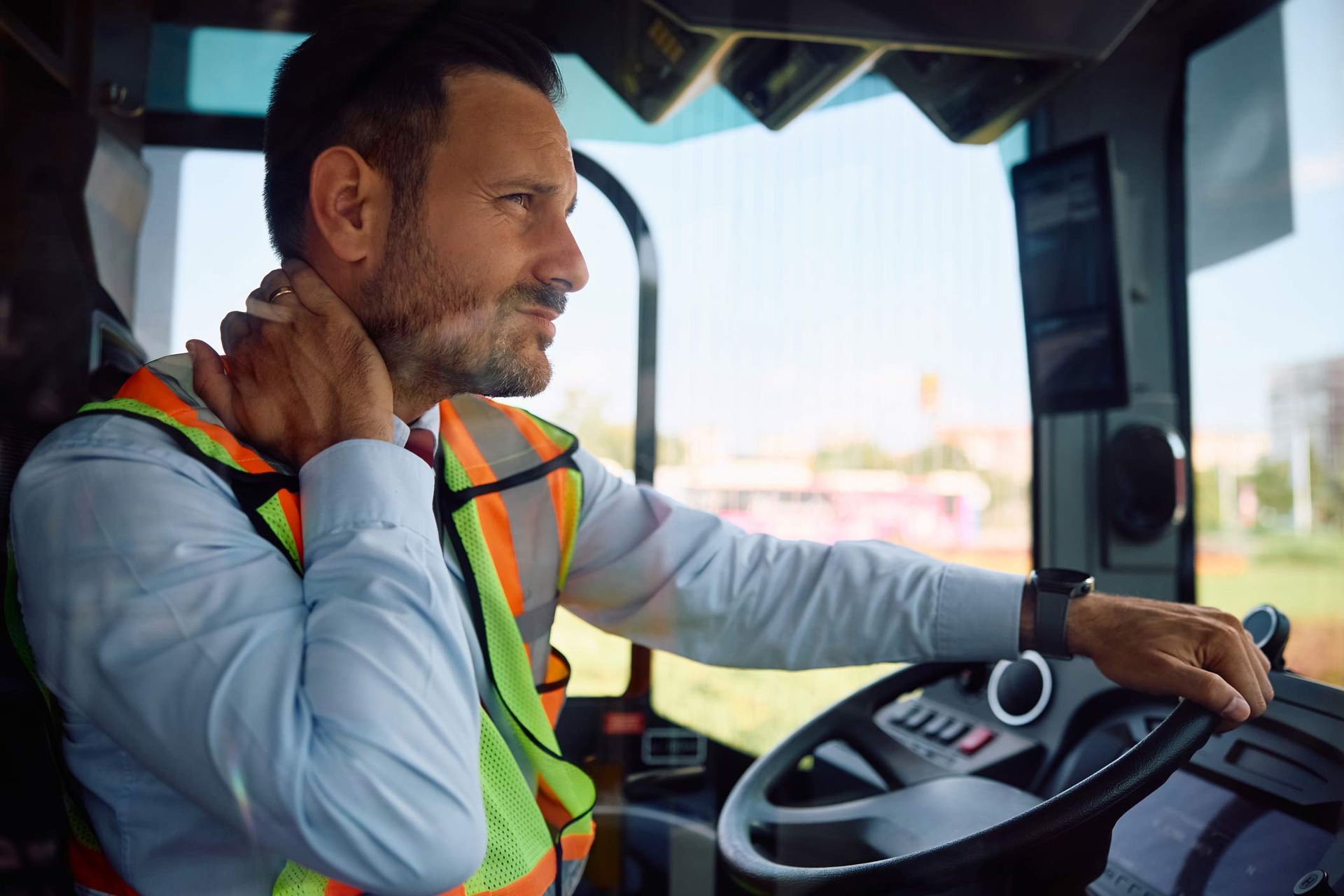 A man is sitting in the driver 's seat of a bus