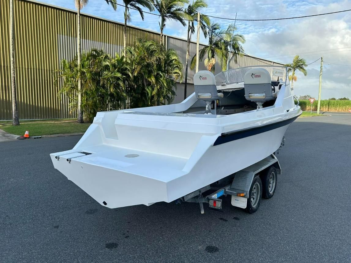 A White Boat Is Parked On A Trailer In Front Of A Building — Murraycraft Fibreglass In Glenella, QLD