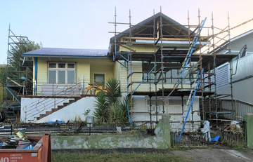 House undergoing renovations with scaffolding around the outside