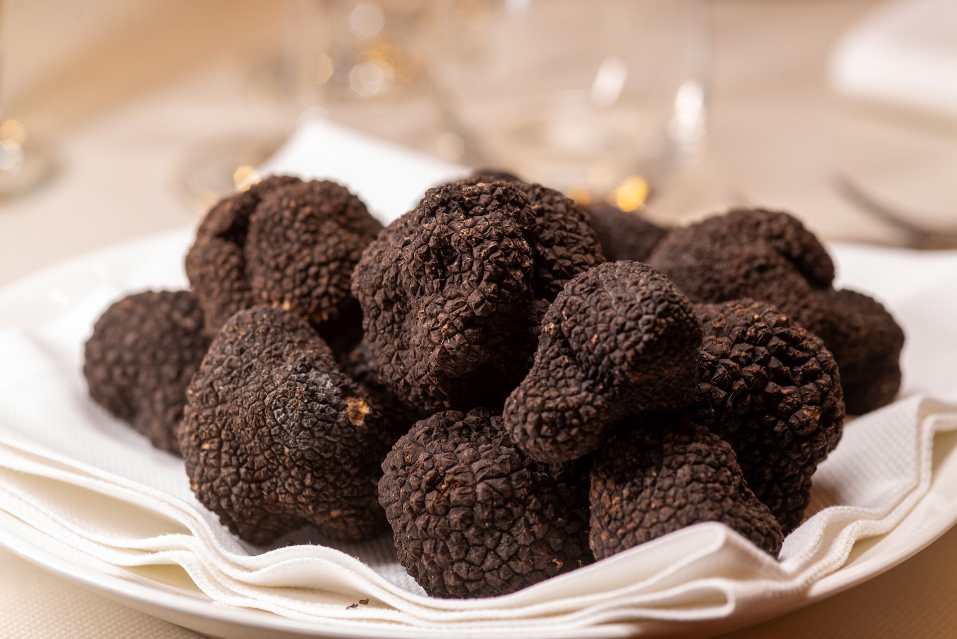 Zwarte truffels op een witte servet, close-up op een restauranttafel.