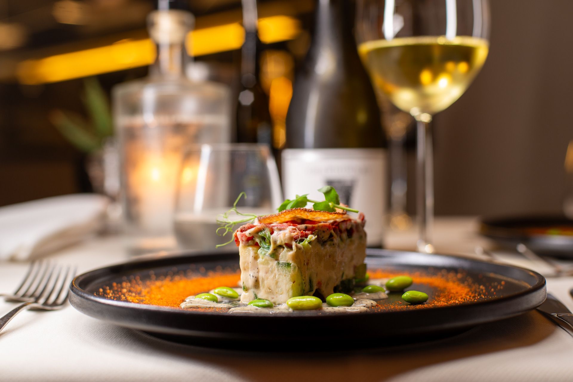 Bord met eten en drinken, restaurantsetting. Het eten is oranje, groen en bruin.